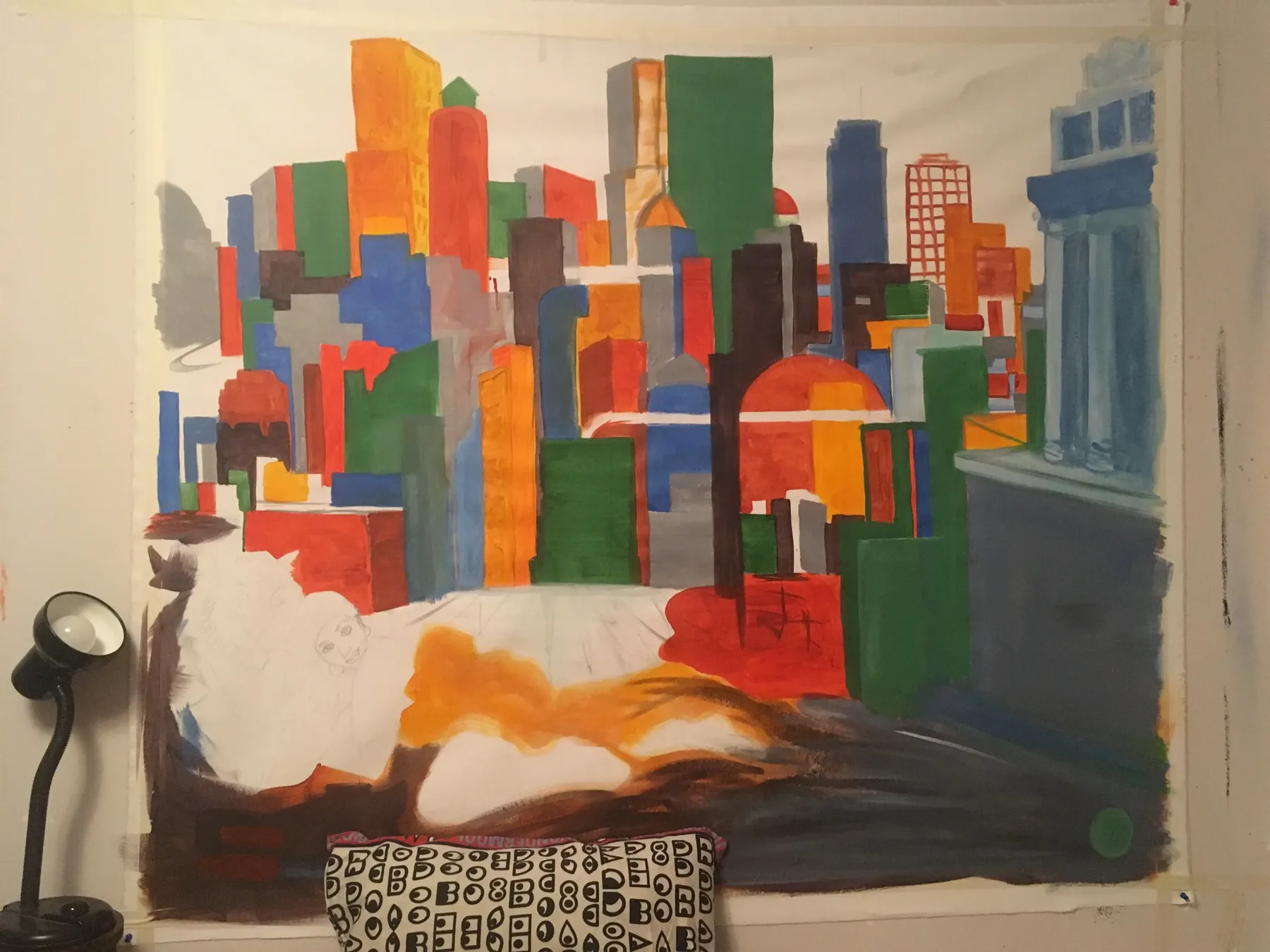 Room-scale painted city forms extending across a wall and furniture